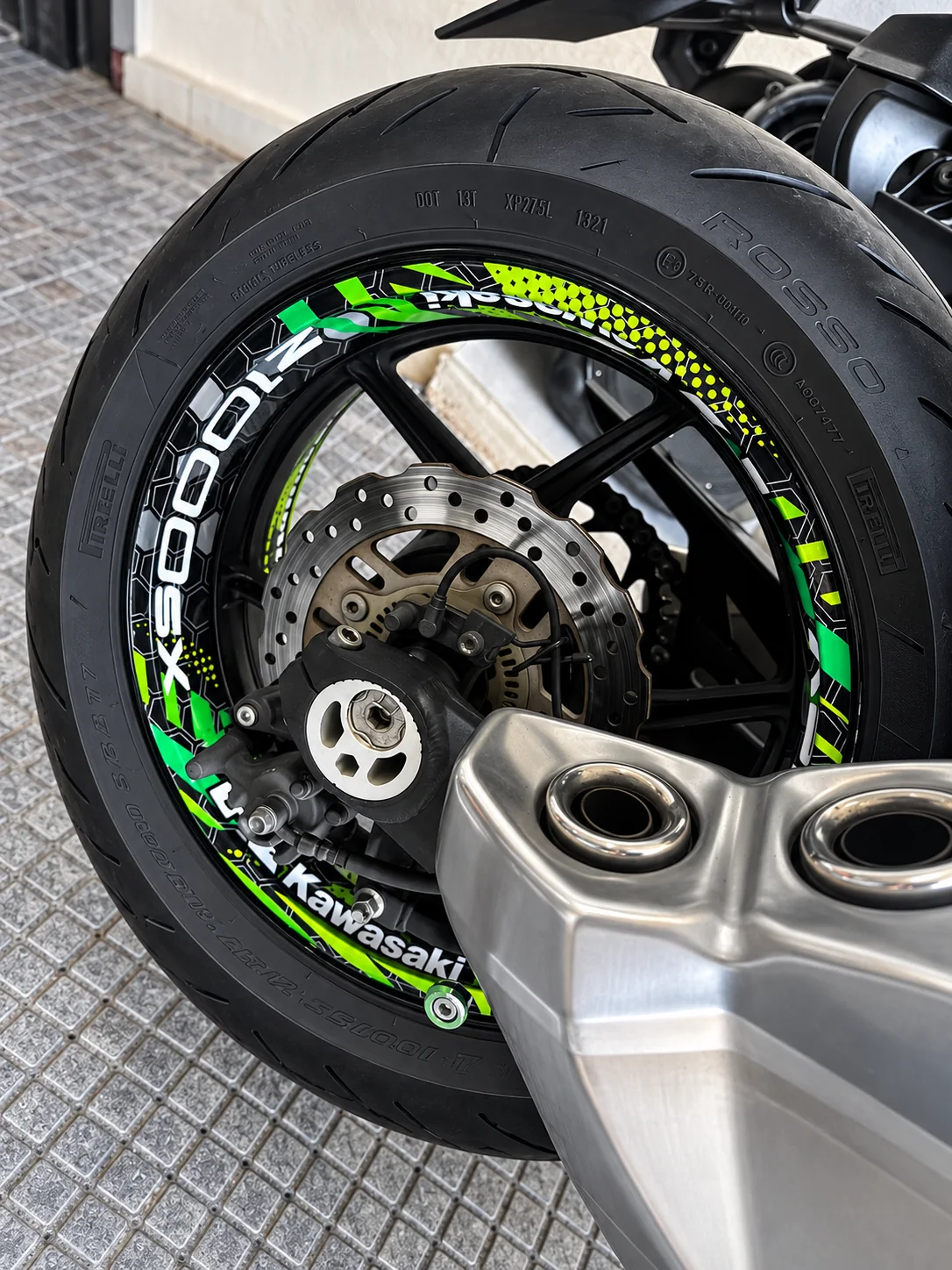 Green and black rim graphics around a Kawasaki street wheel